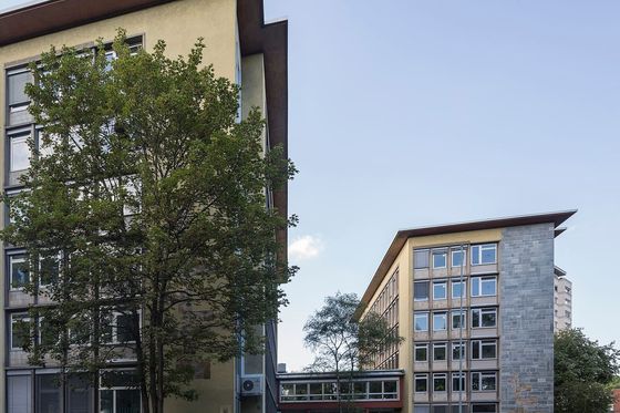 Zwei Bürogebäude eines Finanzamts in Köln mit Bäumen und Straße im Vordergrund