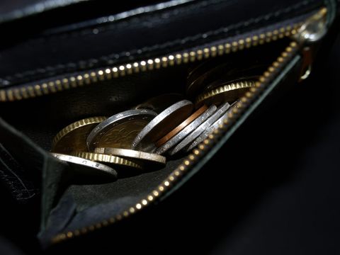 Euro-Münzen in einem geöffneten schwarzen Portemonnaie mit Reißverschluss