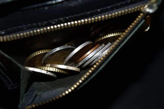 Euro-Münzen in einem geöffneten schwarzen Portemonnaie mit Reißverschluss